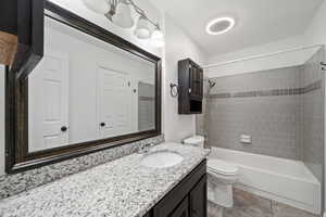 Full bathroom with vanity, toilet, and tiled shower / bath combo