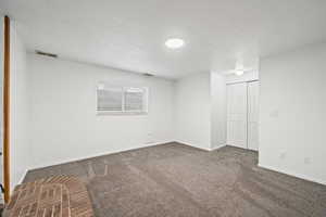 Carpeted empty room with a textured ceiling