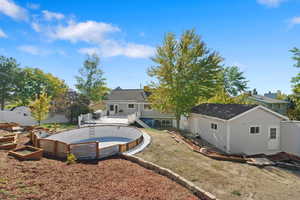 Rear view of property with a lawn and a swimming pool side deck