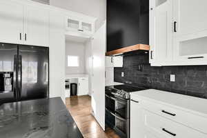 access to the pantry through the Kitchen with a decorative backsplash, premium range hood, double oven range, and white cabinets