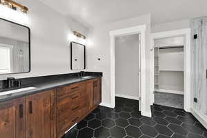 Primary suite Bathroom with tile patterned flooring and double vanity sinks