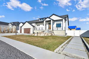 View of front of house featuring a garage and a front lawn