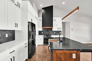 Kitchen featuring a center island with sink, and double oven range