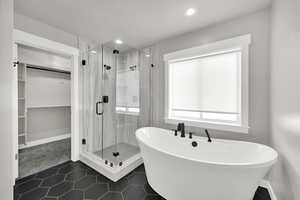 Primary Suite Bathroom with tile floors, dual shower heads in shower, Freestanding soaker bathtub