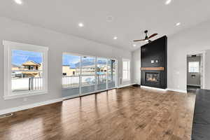 Large Great room with fireplace, laminate flooring, large sliding glass doors and plenty of natural light