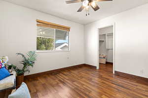 Bedroom featuring ceiling fan, dark hardwood / wood-style flooring, a walk in closet, and a closet