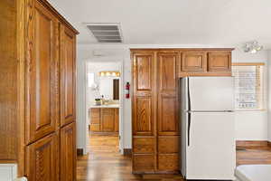 Kitchen with white refrigerator, hardwood / wood-style flooring, and sink