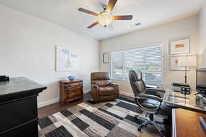 Office area with dark hardwood / wood-style floors and ceiling fan