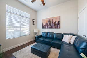 Living room with ceiling fan and dark hardwood / wood-style floors