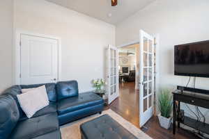 Living room with dark hardwood / wood-style flooring and french doors