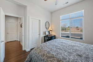 Bedroom with ceiling fan and dark wood-type flooring