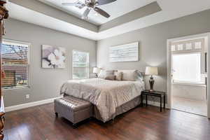 Bedroom featuring ceiling fan, dark hardwood / wood-style flooring, and a raised ceiling