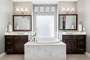 Bathroom featuring tile patterned flooring, vanity, and a bathing tub