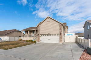 View of front of house with a front lawn, a porch, and a garage