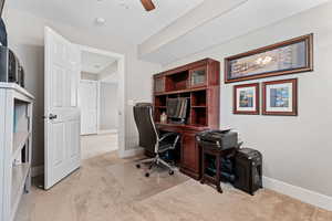 Home office featuring ceiling fan and light carpet