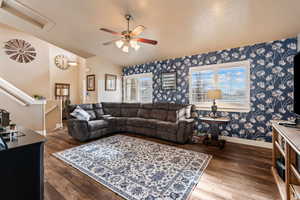 Living room featuring hardwood / wood-style flooring, ceiling fan, and vaulted ceiling