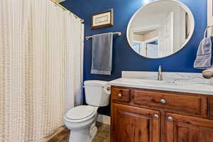 Bathroom featuring tile patterned flooring, vanity, and toilet