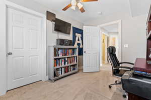 Carpeted office space featuring ceiling fan