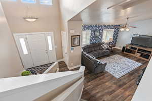 Foyer featuring dark hardwood / wood-style floors, ceiling fan, and a towering ceiling