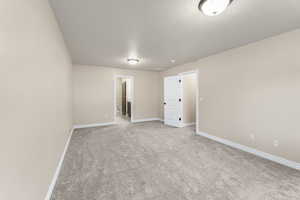 Carpeted spare room with a textured ceiling