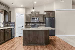 Kitchen featuring a center island, dark brown cabinetry, and stainless steel appliances