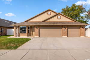 View of front of house with a garage and a front yard