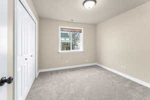 Unfurnished bedroom with carpet and a closet