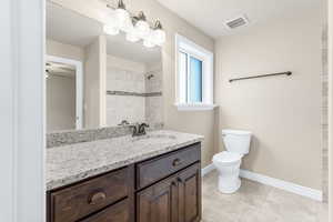 Bathroom featuring ceiling fan, tile patterned flooring, vanity, and toilet