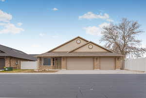 View of front of property with central AC and a garage