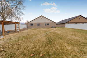 Back of house featuring a lawn and central AC