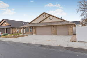 View of front of home with central AC and a garage