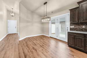 Unfurnished dining area featuring light wood-type flooring and an inviting chandelier