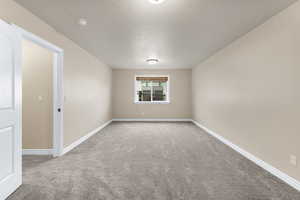 Carpeted empty room with a textured ceiling