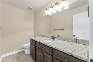 Bathroom featuring tile patterned floors, vanity, and toilet