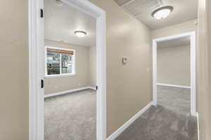 Hall featuring carpet flooring and a textured ceiling