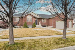 Ranch-style house with a garage and a front lawn