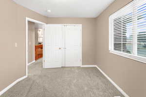 Unfurnished bedroom with carpet and a closet