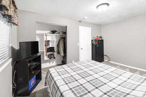 Bedroom featuring a closet, carpet, and a textured ceiling