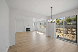 Unfurnished living room featuring a notable chandelier and light hardwood / wood-style flooring