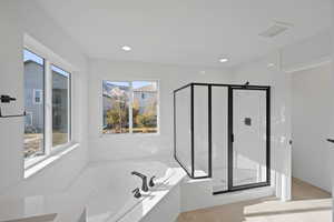 Bathroom with shower with separate bathtub and a wealth of natural light