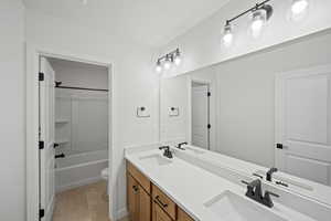 Full bathroom with tile patterned flooring, vanity, toilet, and shower / bath combination