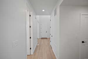 Corridor with light hardwood / wood-style flooring