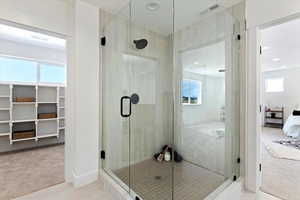 Bathroom featuring tile patterned flooring, a shower with door, and a healthy amount of sunlight