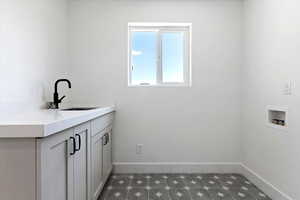 Laundry area featuring cabinets, washer hookup, and sink