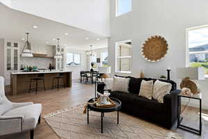 Living room with light hardwood / wood-style floors, a notable chandelier, and sink