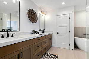 Bathroom featuring a washtub, vanity, and tile patterned flooring