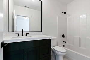 Full bathroom with toilet, vanity, and bathing tub / shower combination