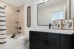 Full bathroom featuring shower / bath combo with shower curtain, vanity, and toilet