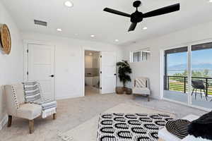 Living area with light colored carpet and ceiling fan