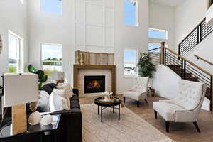 Living room featuring a towering ceiling and light hardwood / wood-style flooring